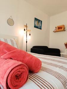 una camera da letto con un letto con asciugamani rossi di Moderne & au centre - Studio a Lorient