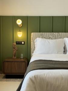 a bedroom with a bed with a green wall at Misk Villa - Boutique Hotel & Spa in Sidi Bou Saïd