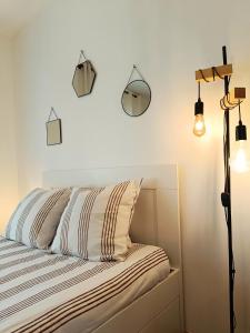 a bedroom with a bed with three lights on the wall at Moderne & au centre - Studio in Lorient