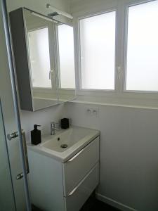 a white bathroom with a sink and two windows at Moderne & au centre - Studio in Lorient