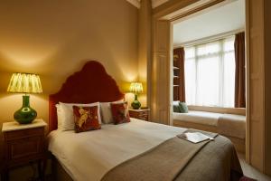 a bedroom with a large bed and a window at Georgian House Hotel in London