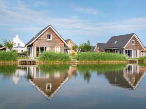 a house is reflected in the water at Dormio Strand Resort Nieuwvliet-Bad in Nieuwvliet