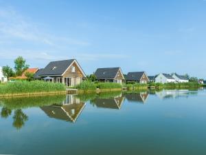 a row of houses next to a body of water at Dormio Strand Resort Nieuwvliet-Bad in Nieuwvliet