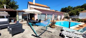 un patio con mesa, sombrilla y piscina en Sossego da Laurinda, en Vila Praia de Âncora