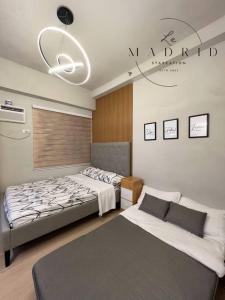 a bedroom with two beds and a chandelier at Nordic-Industrial Minimalist in Manila