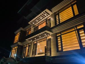 a large building with windows at night at Uptown Boutique Homes - Room 1 in Shimla
