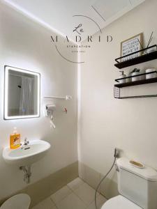 a white bathroom with a toilet and a sink at Nordic-Industrial Minimalist in Manila