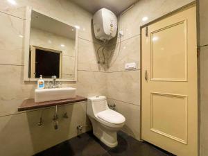 a bathroom with a toilet and a sink and a mirror at Uptown Boutique Homes - Room 1 in Shimla