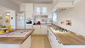 a kitchen with white cabinets and a counter with a bowl of fruit at XXL Luxury villa near Split for up to 16 people in Kaštela