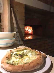 a pizza on a plate on a table in front of an oven at Il Pino “Villa Nunzia” in Ischia