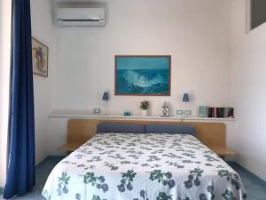 una camera da letto con un letto con un copriletto floreale; di Il Pino “Villa Nunzia” a Ischia