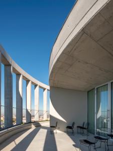 uma varanda com cadeiras e mesas num edifício em micampus Porto Tower no Porto