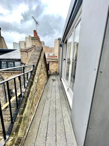 uma varanda com piso em madeira e janelas num edifício em Drury Lane Residences em Londres