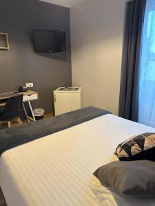 a bedroom with a large bed with a tv on the wall at Dolce Vita in Mondorf-les-Bains