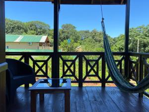 a porch with a hammock and a view of the forest at Cabañas del Chachi in Oberá