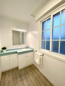 un bagno con lavandino, specchio e finestra di "A Marosa", bonito chalet dúplex a Cangas de Morrazo