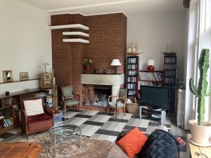 a living room with a couch and a fireplace at Petite Source in Varengeville-sur-Mer