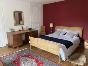 1 dormitorio con cama, escritorio y espejo en Petite Source en Varengeville-sur-Mer