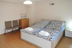 a bedroom with a bed and two chairs in it at Apartament Pod Wieżyczkami in Międzyzdroje