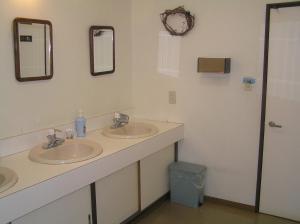 uma casa de banho com dois lavatórios e dois espelhos em Pension Young House em Furano