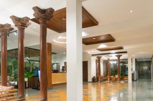 a lobby of a hotel with columns and tables at Pathikashram Nilaya in Gandhinagar +15 photos