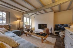 ein Wohnzimmer mit einem Sofa und einem TV in der Unterkunft Maison de Suzon 