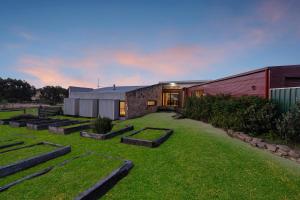 a large yard with a building and some grass at Unique and Modern Farm Stay with Pool and Foosball and Yard in Buninyong