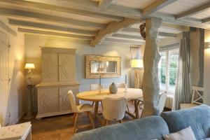 a living room with a table and a blue couch at Maison de Suzon in Saint-Pierre-le-Viger