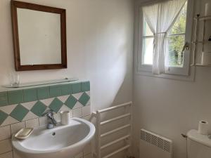 a bathroom with a sink and a mirror and a window at Maison des Petites Bruyeres 6 in Varengeville-sur-Mer