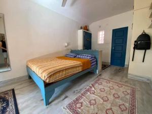 a bedroom with a bed and a blue door at Neela House in Kovalam