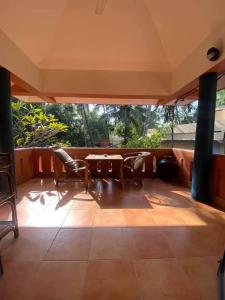 a patio with chairs and a table on a porch at Neela House in Kovalam