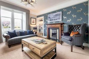 sala de estar con sofá y chimenea en Daisybank Kingsbarns - Beautiful 3 Bedroom Cottage en Kingsbarns