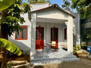 a small white house with a table and chairs at Eden House & Coffee Con Dao in Con Dao