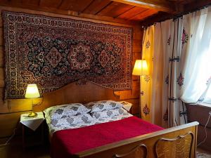 ブコビナ・タトシャンスカにあるDomek Pod Kogutkiem Na Dolinieのベッドルーム1室(赤毛布、ランプ2つ付)