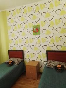 SunLake Hotel Osokorki في كييف: غرفة نوم بسريرين وجدار بقلوب