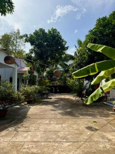 a courtyard of a house with trees and plants at Eden House & Coffee Con Dao in Con Dao
