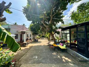 a patio with tables and chairs and a tree at Eden House & Coffee Con Dao in Con Dao