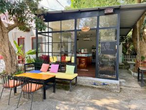 a patio with a table and chairs in front of a store at Eden House & Coffee Con Dao in Con Dao