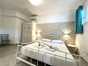 una camera con letto bianco di Angolo Mare Apartments & Rooms a Porto Pino