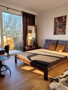 a bedroom with a large bed with a large window at Apartmán Senica in Senica