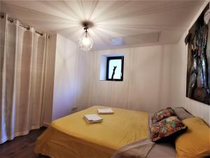 um quarto com uma cama amarela e uma janela em La détente em Veyrier-du-Lac