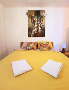 een groot geel bed met twee witte kussens erop bij La détente in Veyrier-du-Lac