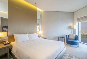 a bedroom with a bed and a desk and a chair at HomesGetaway-Lavish STU in Hyatt Regency Creek Heights Residences in Dubai