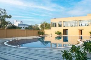 a swimming pool in front of a building at Pathikashram Nilaya in Gandhinagar