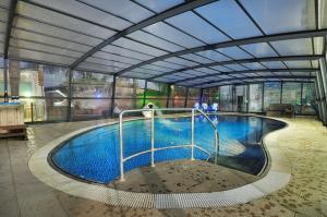 - une grande piscine dans un bâtiment dans l'établissement בקתות גן עדן, à Kallanit