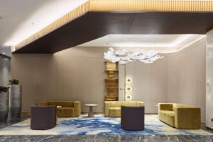 eine Lobby mit Sofas und einem Kronleuchter in der Unterkunft Howard Johnson Paragon Hotel Beijing Central in Peking