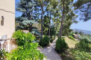 un jardín frente a una casa con árboles en Villa Fazia, en Ortezzano