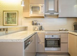 a kitchen with a stove and a microwave at HomesGetaway-Lavish STU in Hyatt Regency Creek Heights Residences in Dubai