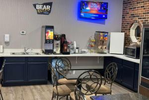 a kitchen with a counter with a table and chairs at Travelodge by Wyndham Airport Platte City in Platte City