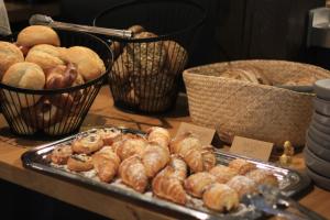 una mesa con una bandeja de bollería y cestas de pan en EDELFUCHS-LODGE en Bühlertal